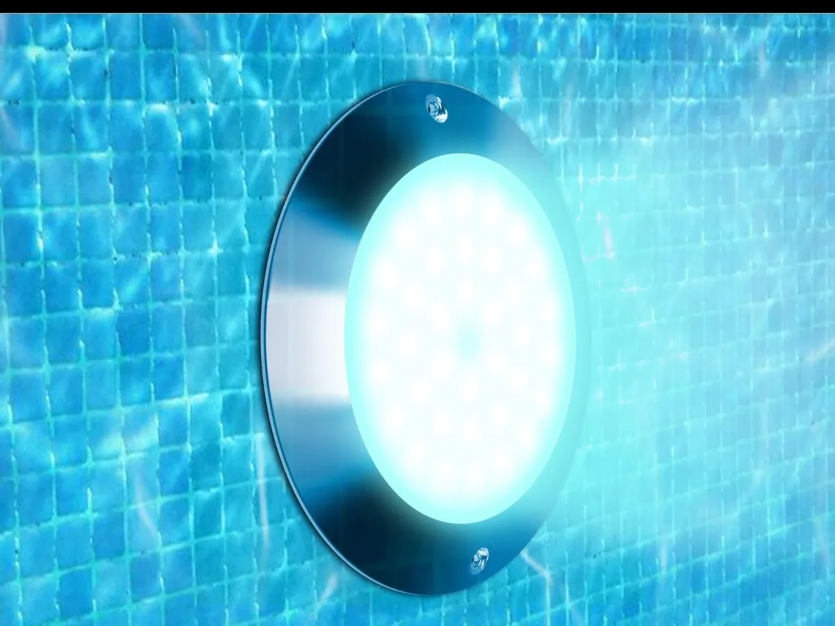 A round pool light glowing white under rippling pool water